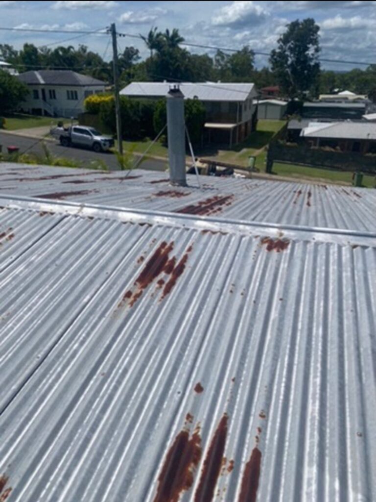 Old metal roof showing severe rust patches needing professional roof restoration